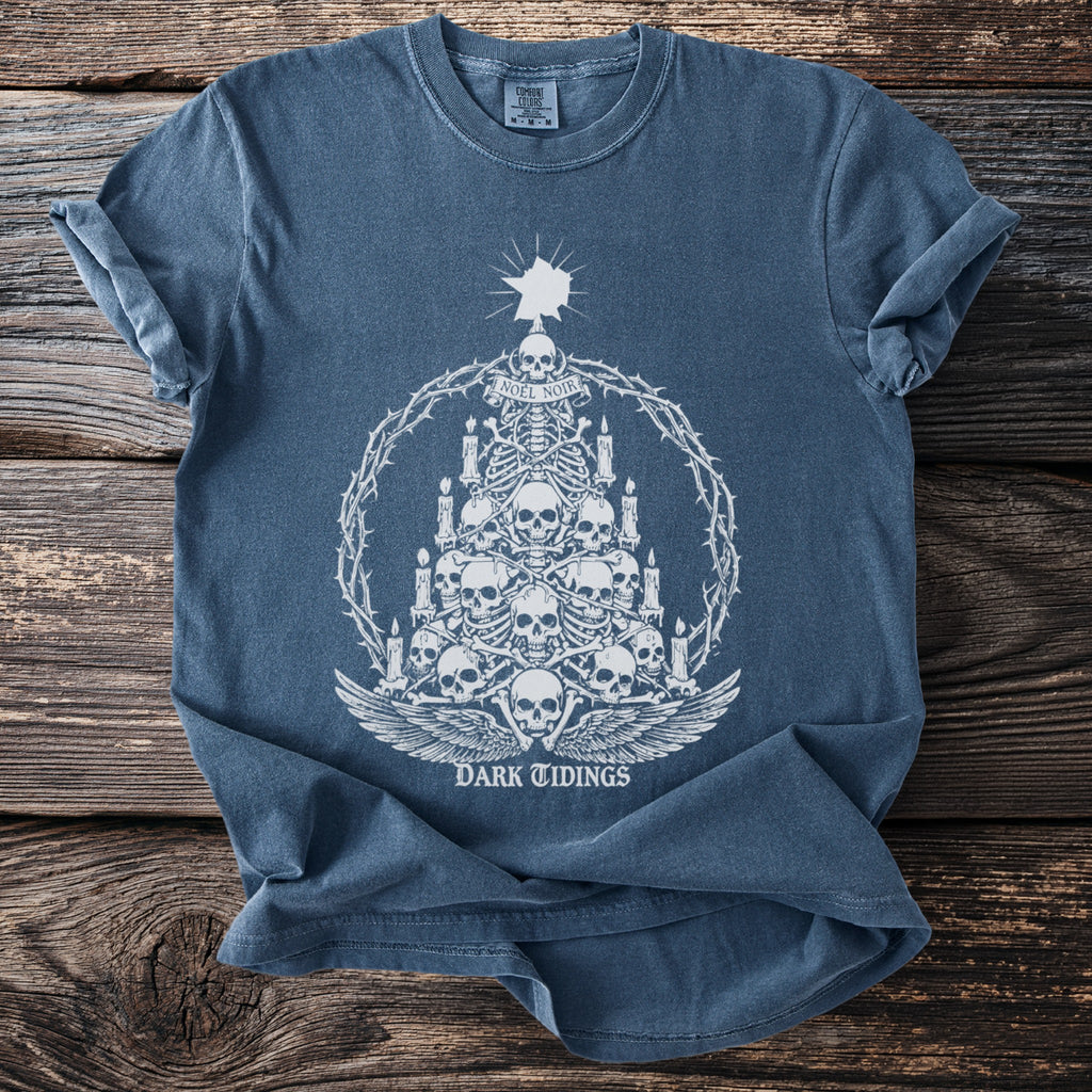 Blue t-shirt with white graphic of a skull tree, candles, and "DARK TIDINGS" text.
