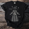 Black t-shirt with white graphic of a witch adorned with Poison Hemlock and Monkshood plants.