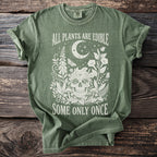 Green t-shirt with "All Plants Are Edible Some Only Once" and floral skull design.