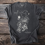 Dark t-shirt with white line art of a witch holding Jimsonweed and Deadly Nightshade flowers.