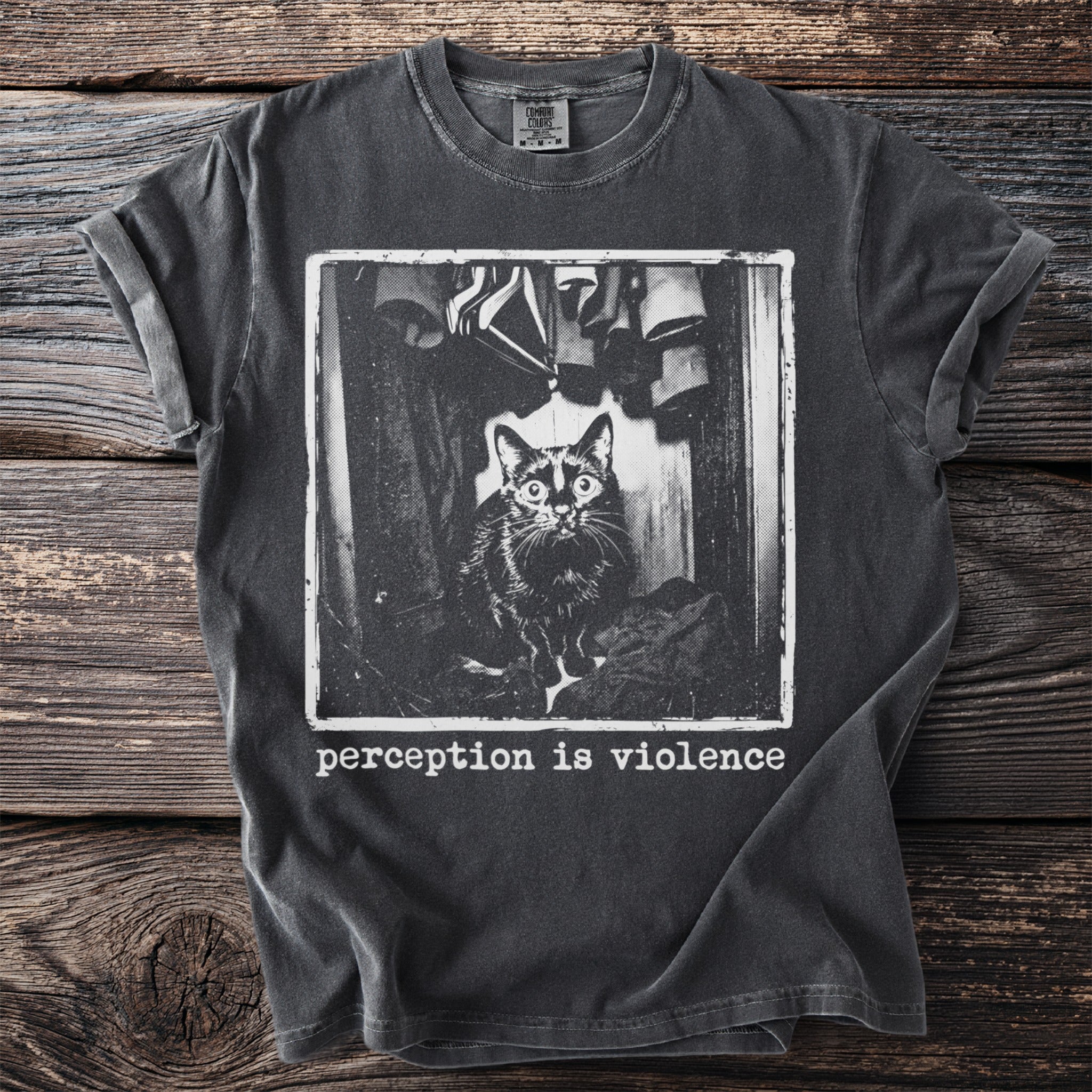 Dark t-shirt with black and white print of a cat in a closet and text "perception is violence".