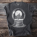 Dark t-shirt with white graphic of haunted house in a snow globe under a full moon.