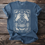 Blue t-shirt with occult graphic of hands, crystal ball, moths, candles, and celestial symbols.