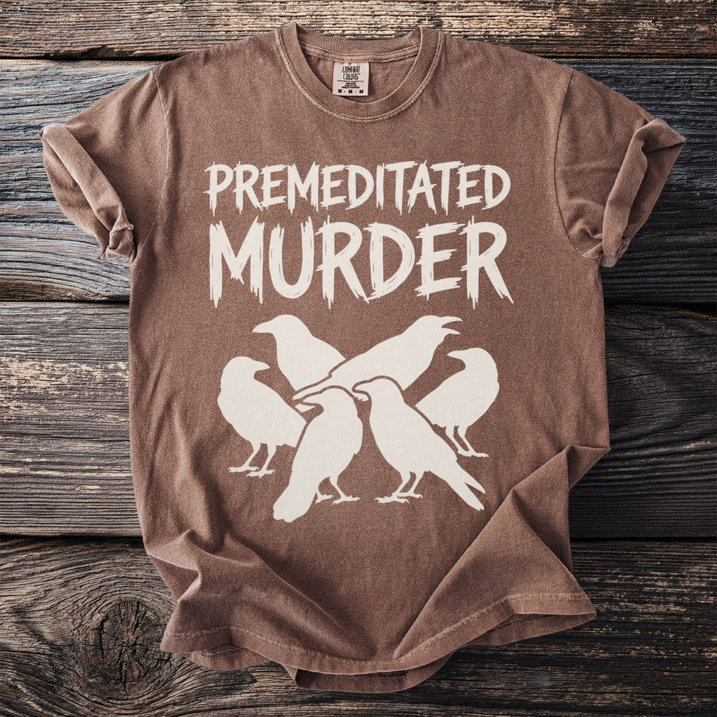 Brown t-shirt with white text "PREMEDITATED MURDER" above a flock of ravens.