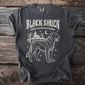 Dark gray t-shirt featuring a ghostly hound, graveyard, and church graphic with "BLACK SHUCK" text.