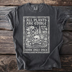 Dark grey t-shirt with white text and illustration of skull, bones, and plants.