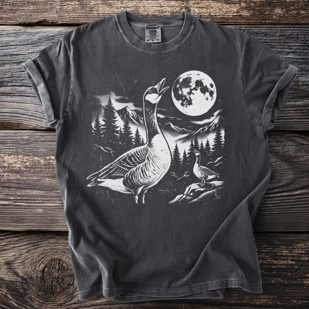 Graphic t-shirt with geese, mountains, trees, and a full moon at night.