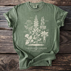 Green t-shirt with "The Poison Garden" text and botanical illustrations of poisonous plants.