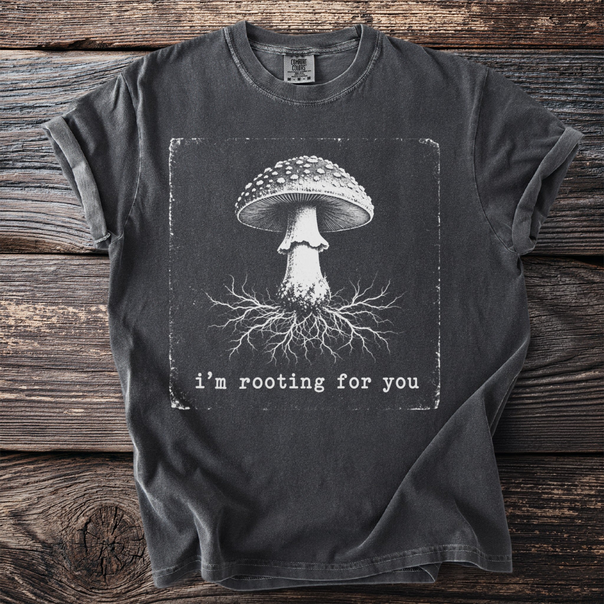 Dark t-shirt with graphic of mushroom and roots with text "i'm rooting for you."