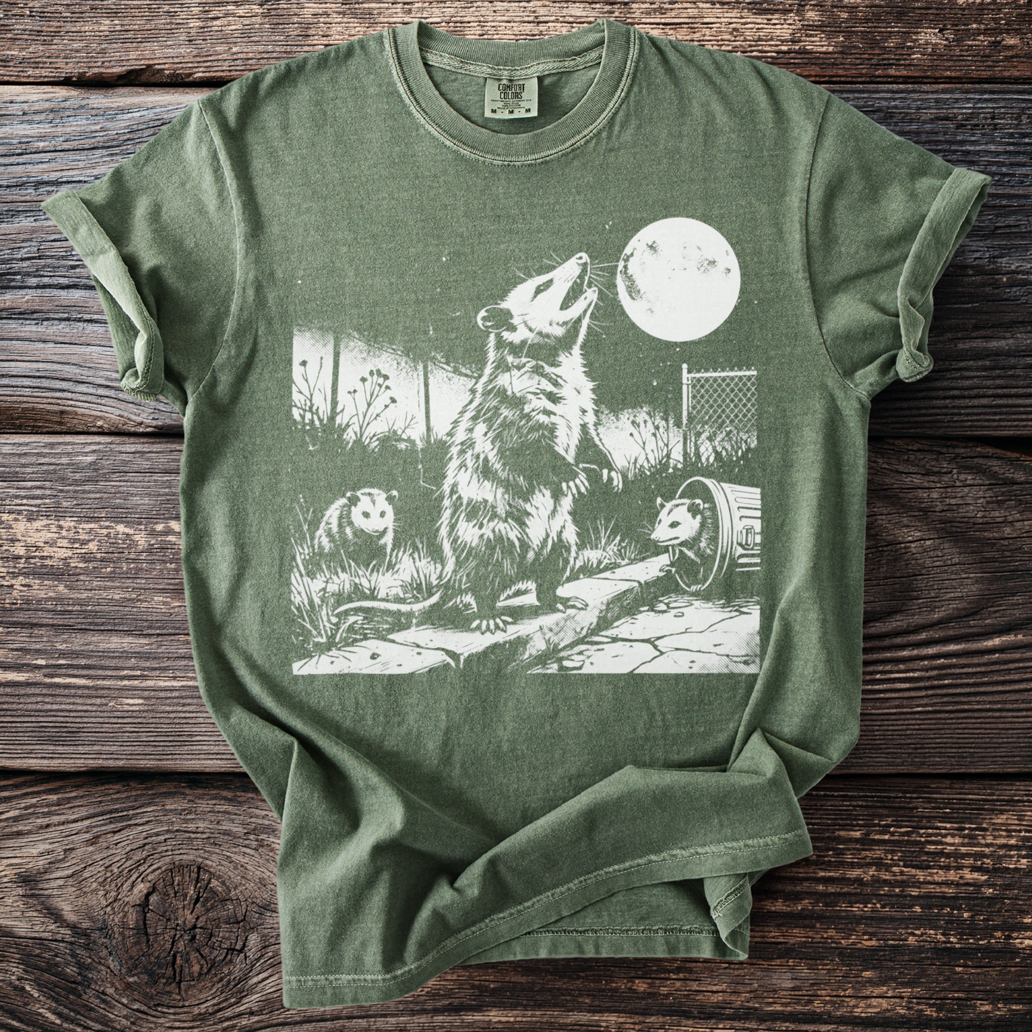 Green t-shirt with distressed graphic of three opossums and a full moon.