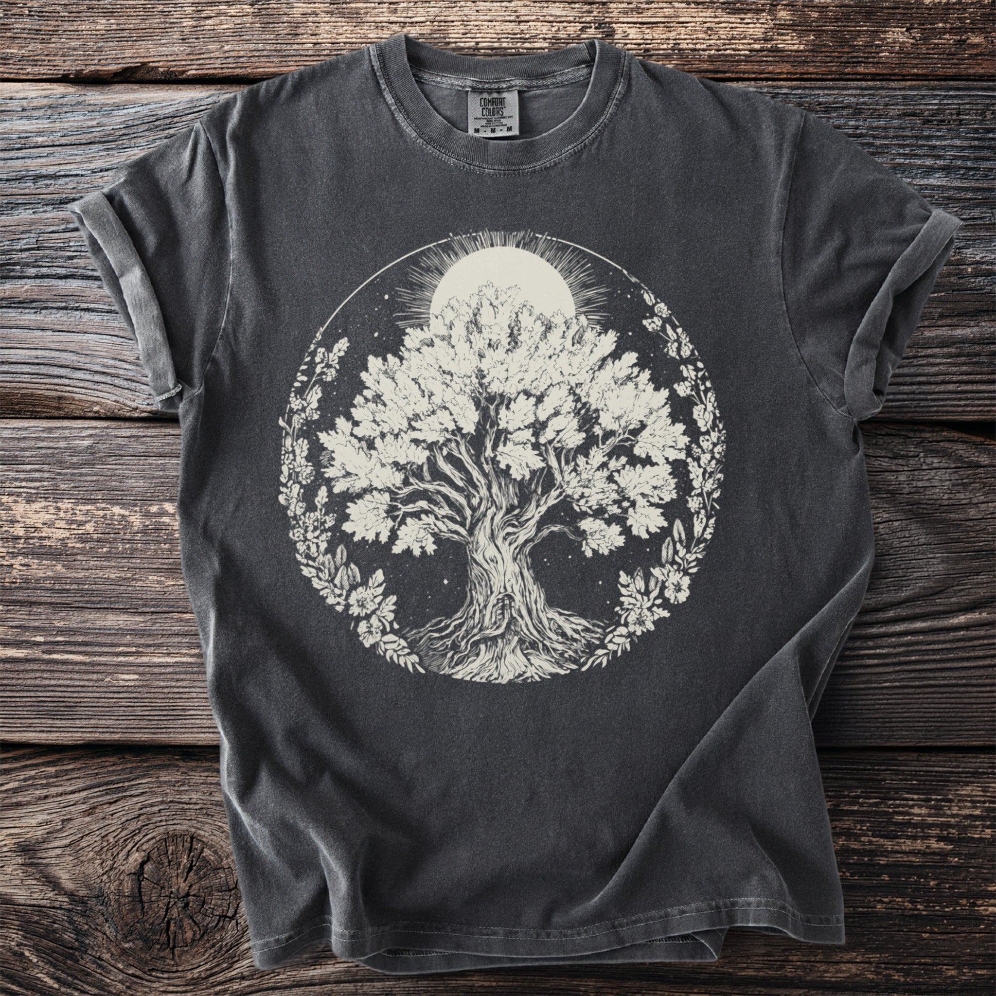 Dark gray t-shirt with a white graphic of a tree of life inside a floral wreath.