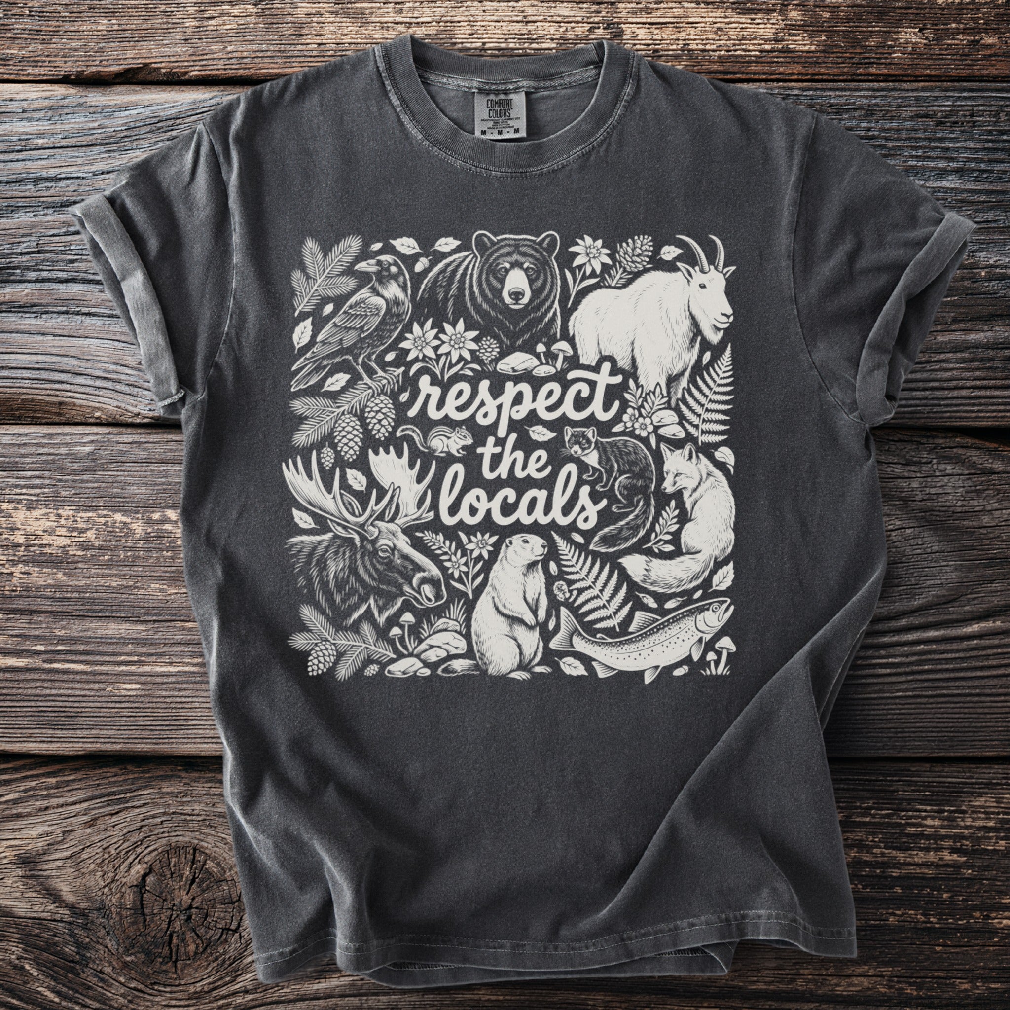 Dark grey t-shirt with white illustration of forest animals and text "respect the locals".