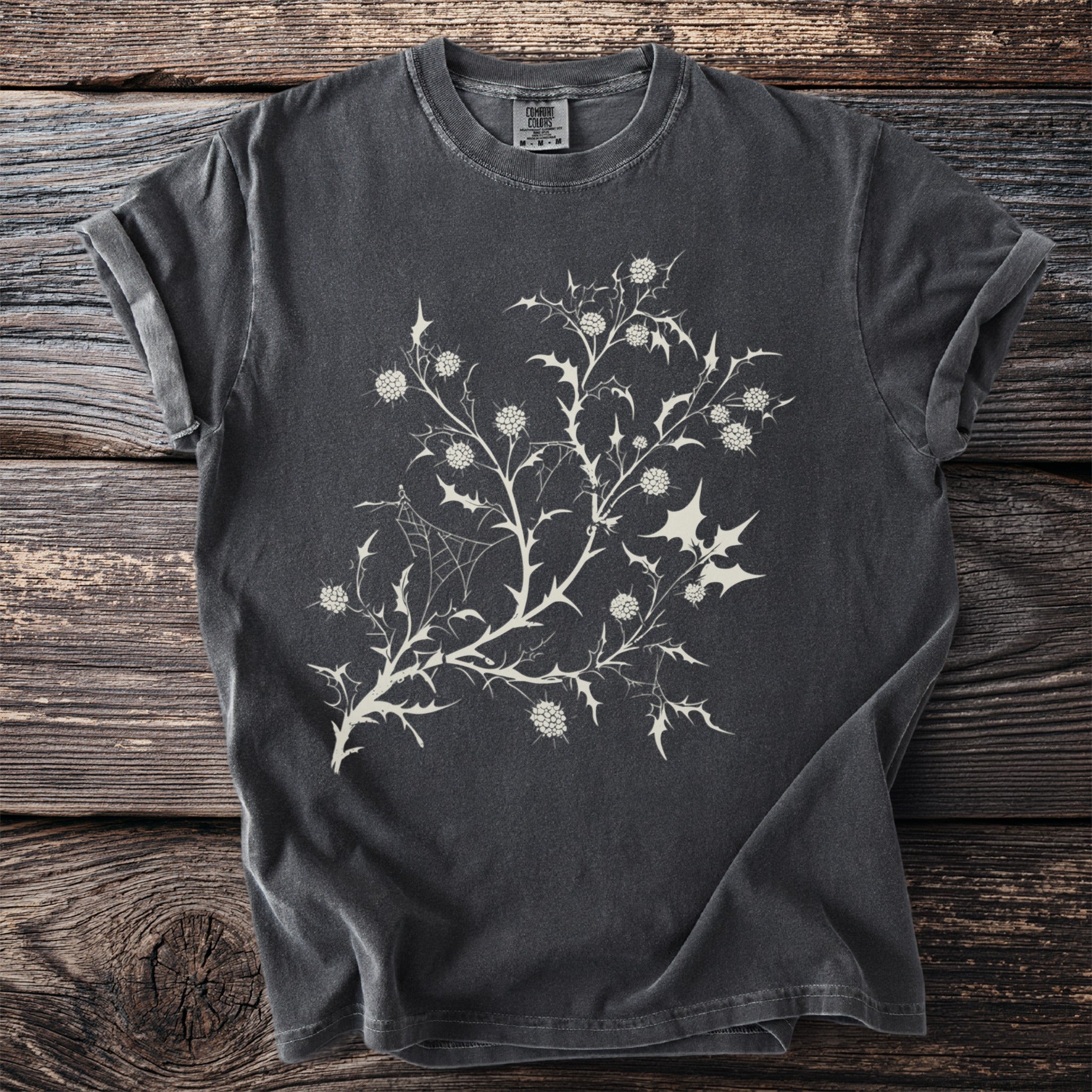 Dark gray t-shirt with a cream-colored thistle and spiderweb graphic.