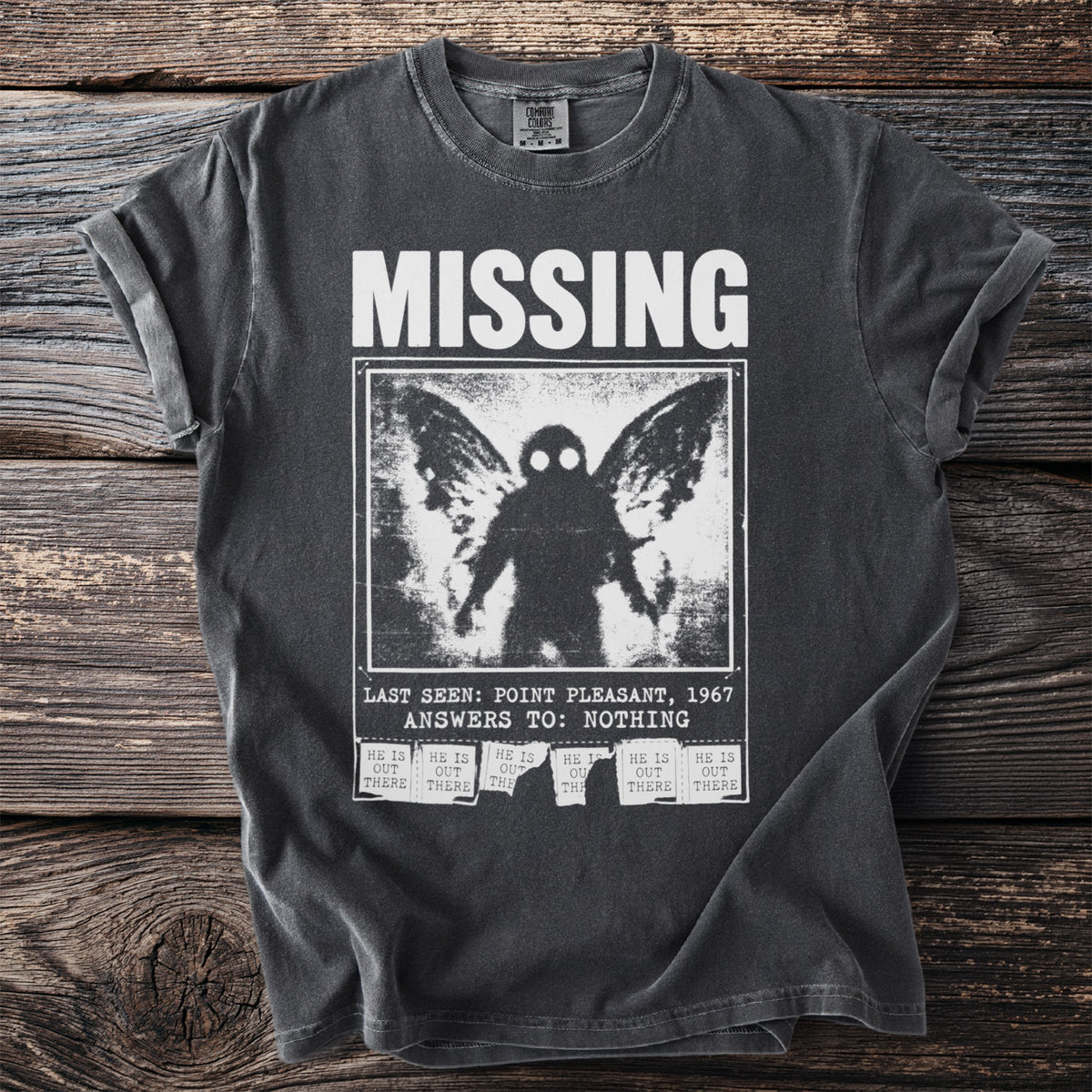 Dark t-shirt with white text and a Mothman image: "MISSING LAST SEEN: POINT PLEASANT, 1967 ANSWERS TO: NOTHING".