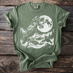 Green t-shirt with two ravens, full moon, and forest scene graphic.