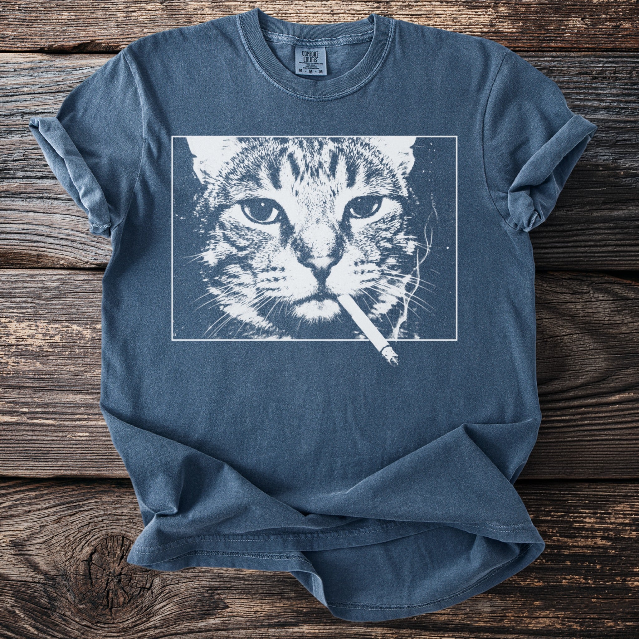 Blue t-shirt with white graphic of a cat smoking a cigarette.
