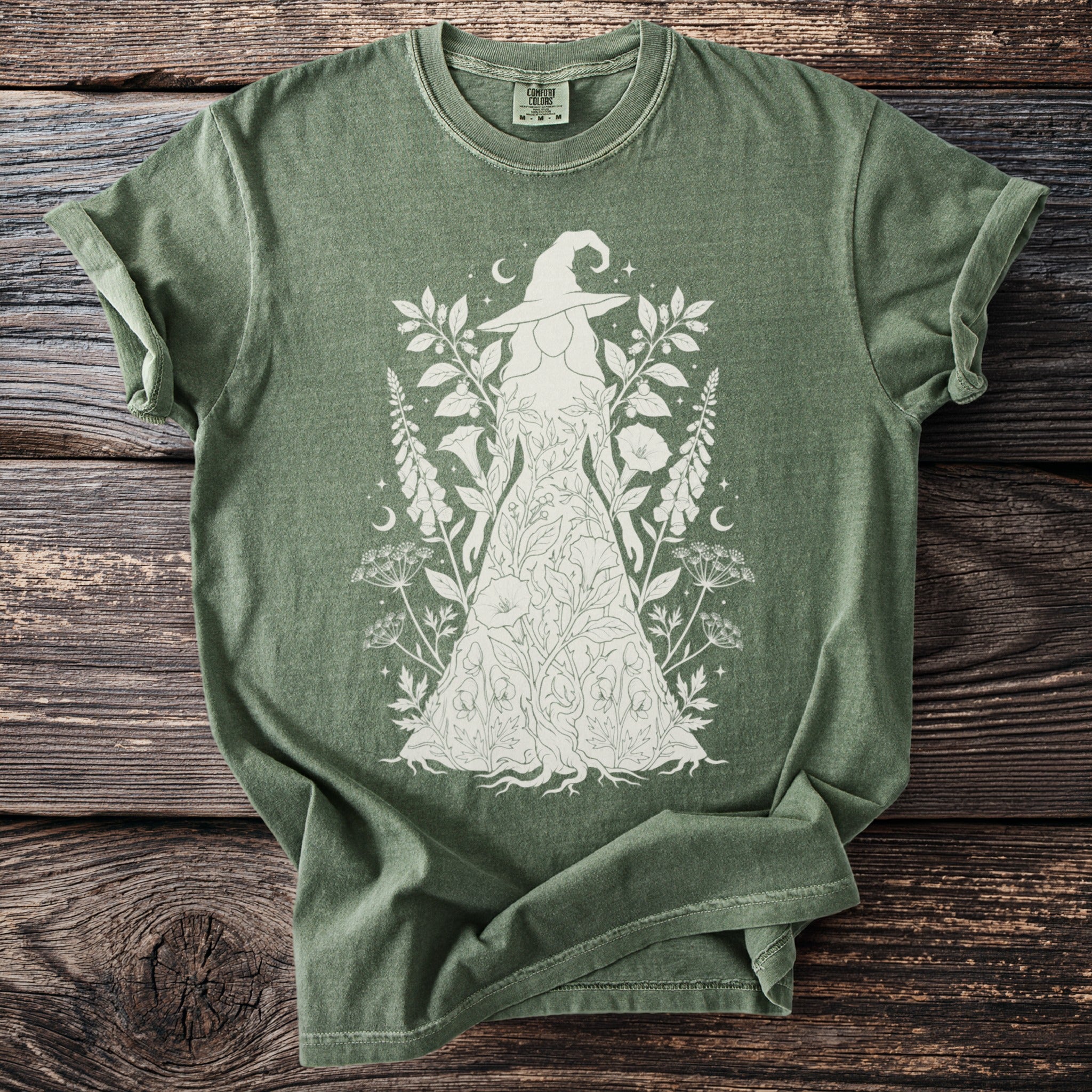 Green Comfort Colors t-shirt with white witch and floral botanical design.