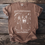 Brown t-shirt with three witches and text "god forbid women have hobbies".