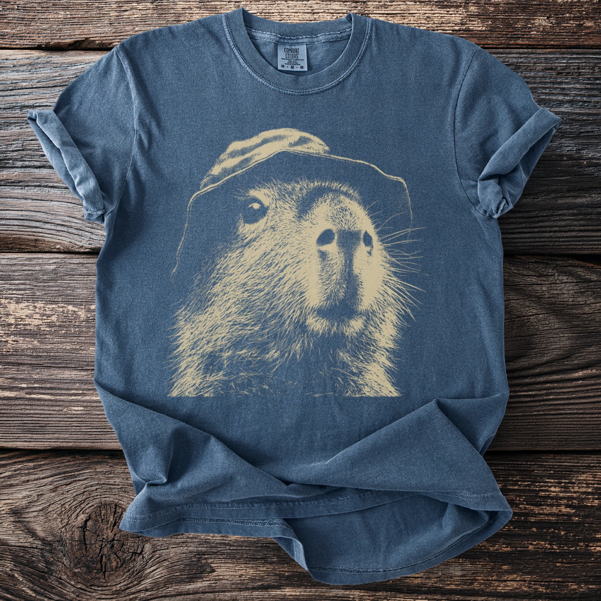 Blue t-shirt with a light brown drawing of a groundhog wearing a hat.