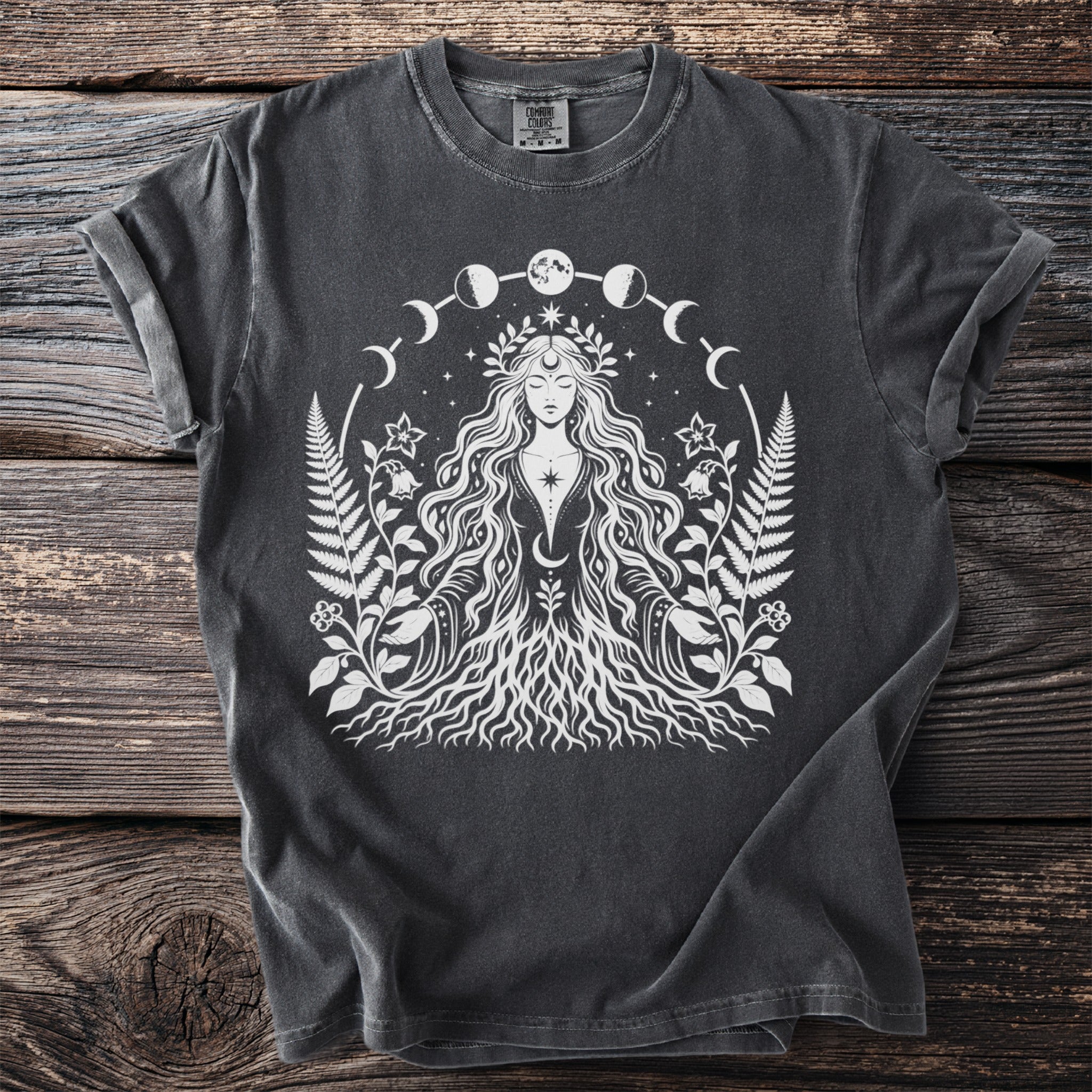 Dark grey t-shirt with white illustration of a female figure surrounded by moon phases and foliage.