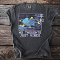 Dark t-shirt with capybara bathing in citrus fruit and text "NO THOUGHTS JUST VIBES".