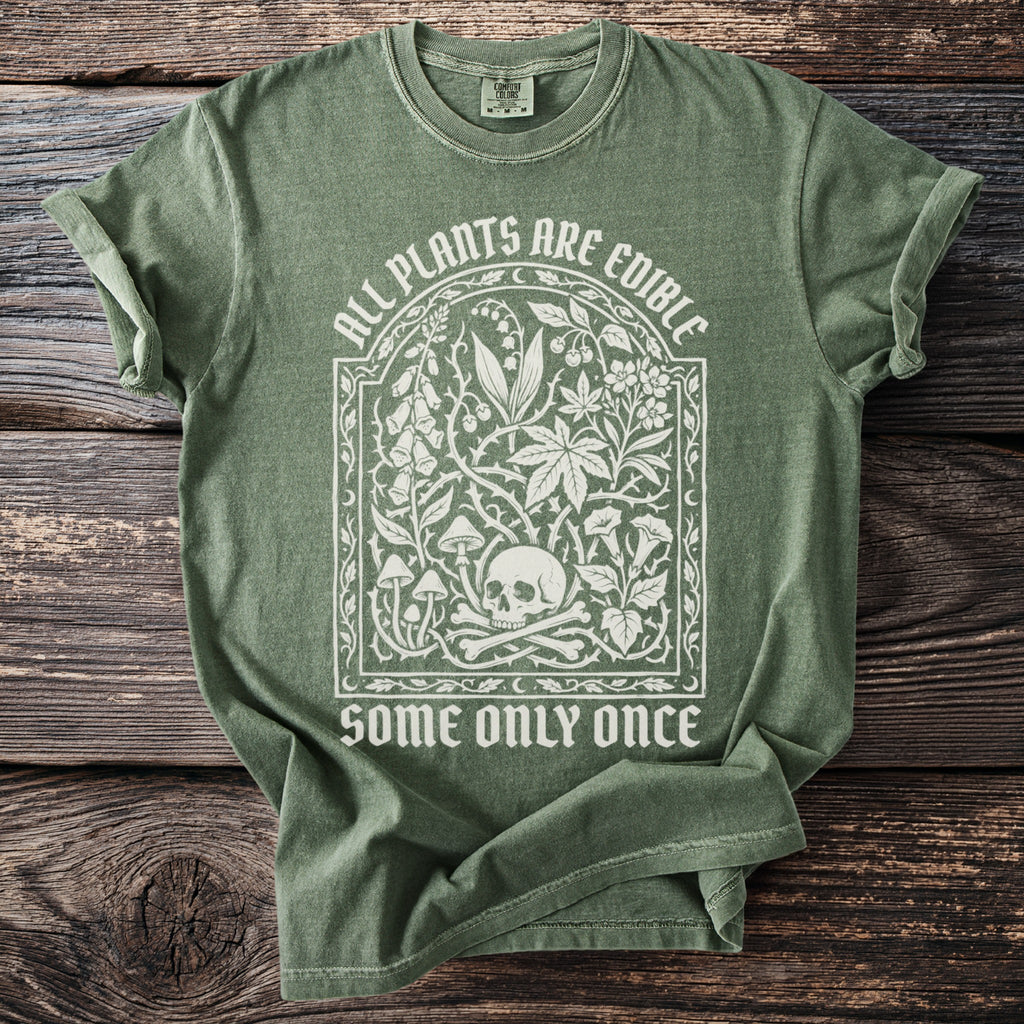 Green t-shirt with white graphic: "All Plants Are Edible Some Only Once" and skull.
