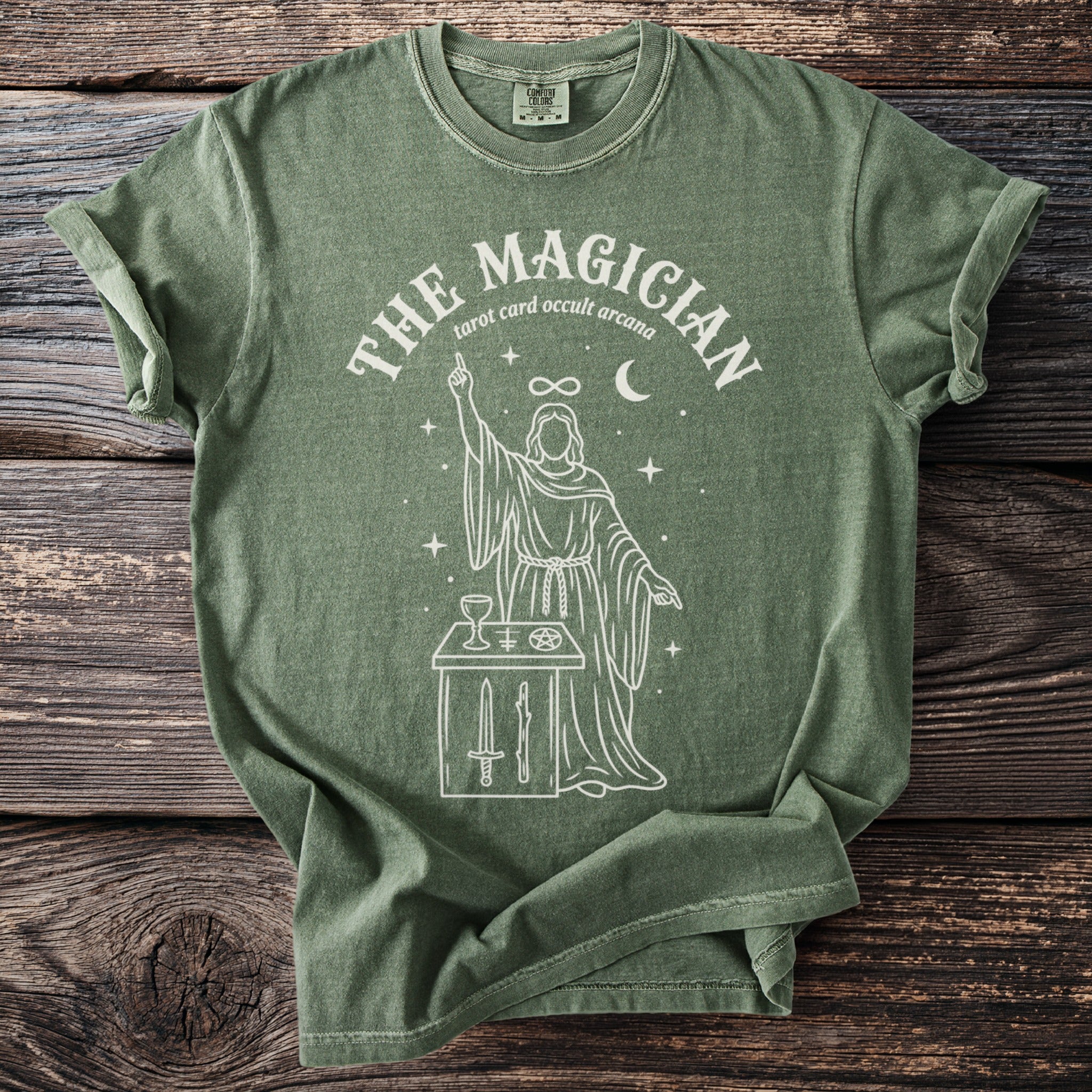 Green t-shirt with white line art of "The Magician" tarot card with occult symbolism.