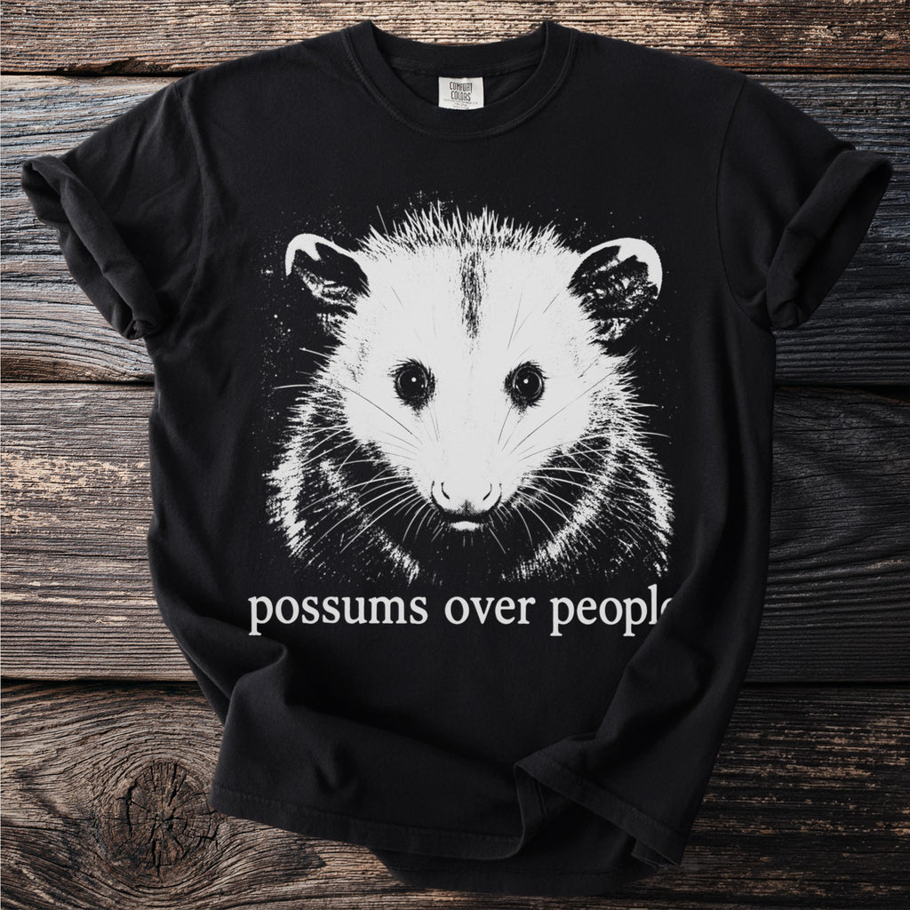 Black t-shirt with white possum graphic and "possums over people" text.