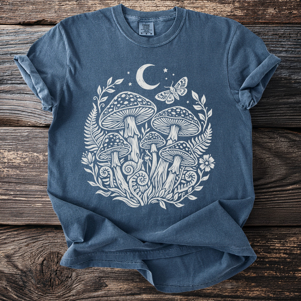 Blue t-shirt with white mushroom, moon, stars, and butterfly graphic.
