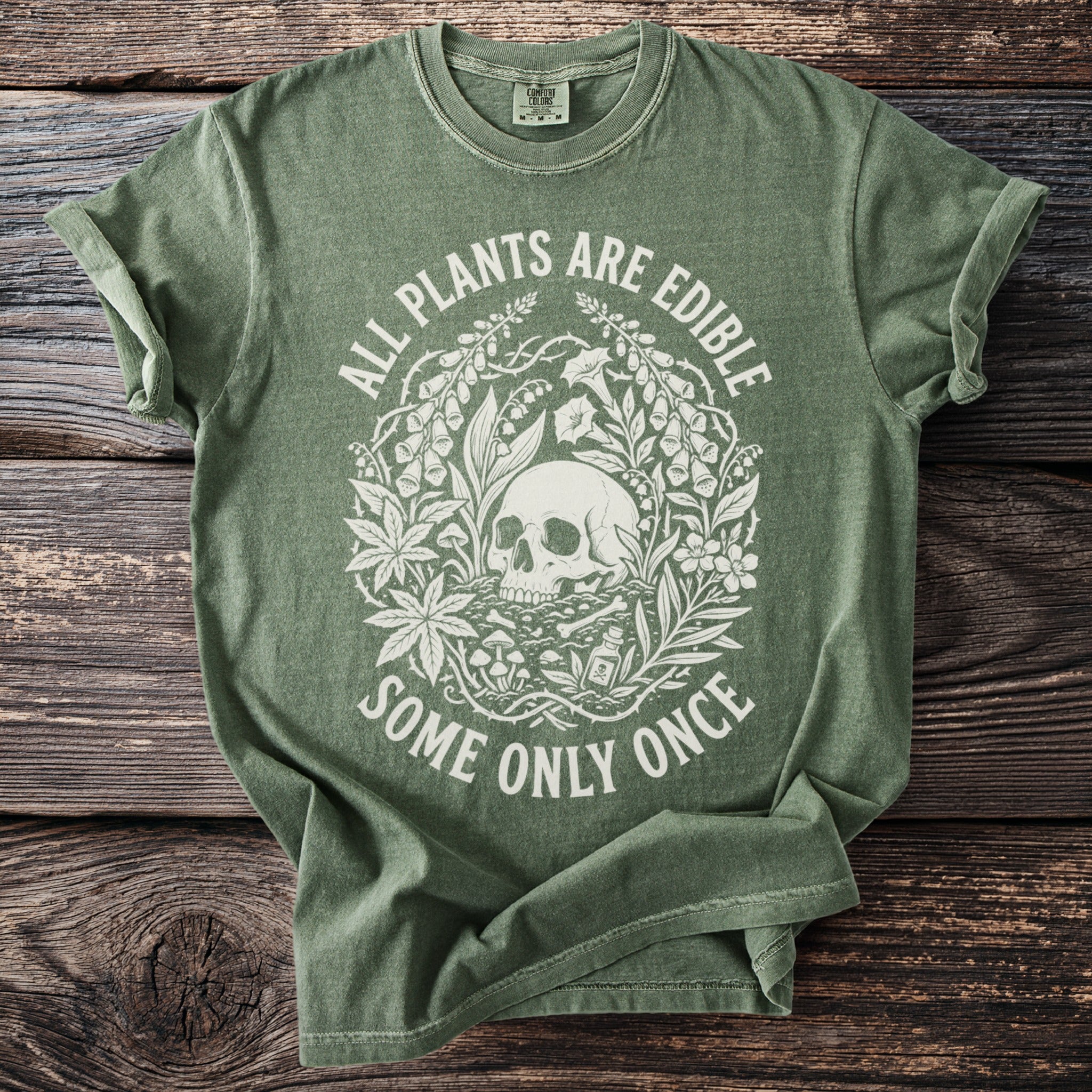 Green t-shirt with skull and plants graphic and text "All Plants Are Edible Some Only Once".