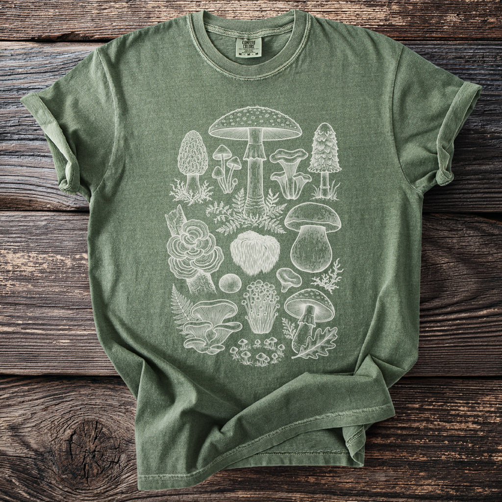 Green t-shirt with a white line drawing of various mushrooms and ferns.