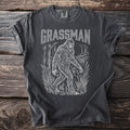 Dark grey t-shirt with white Grassman Bigfoot graphic.