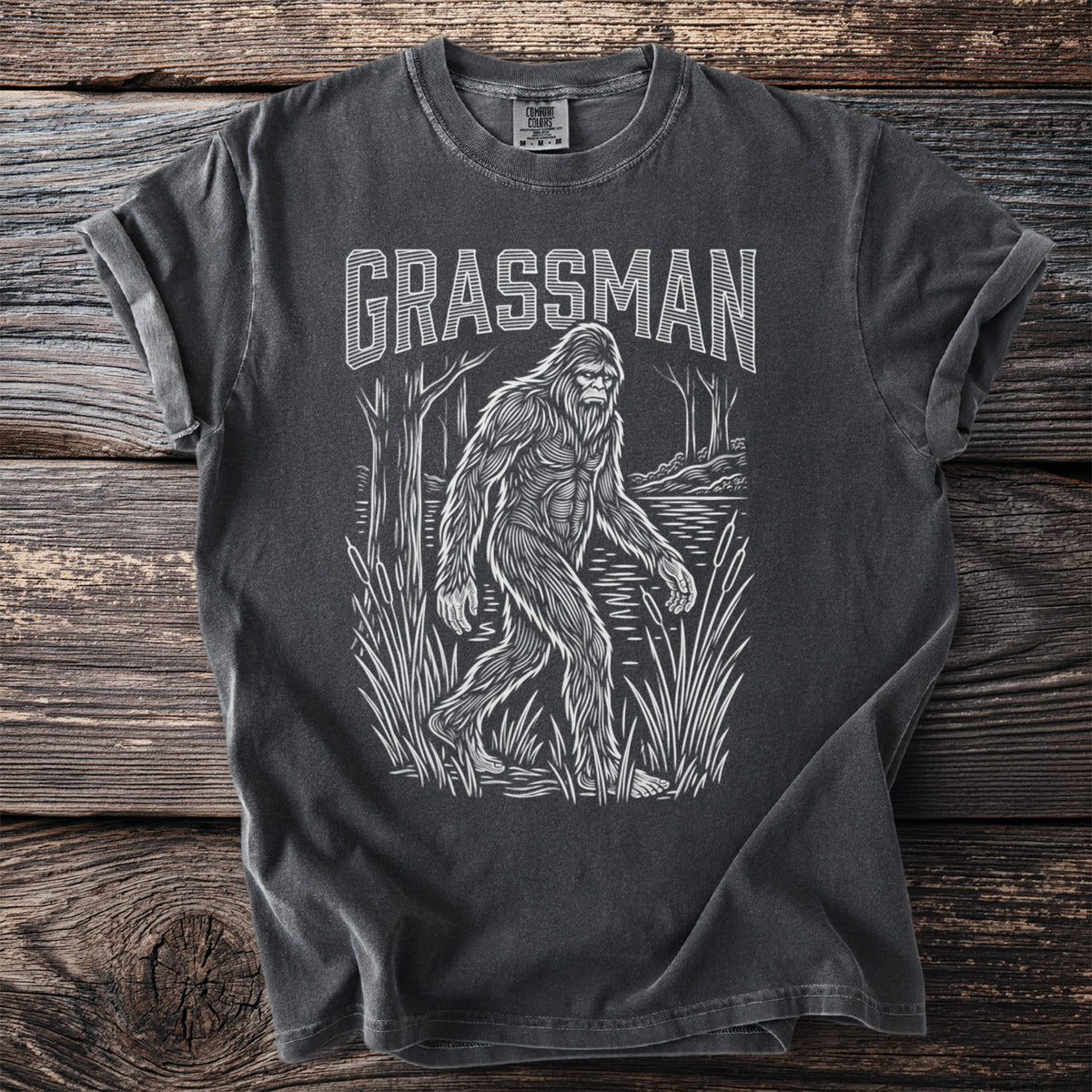 Dark grey t-shirt with white Grassman Bigfoot graphic.
