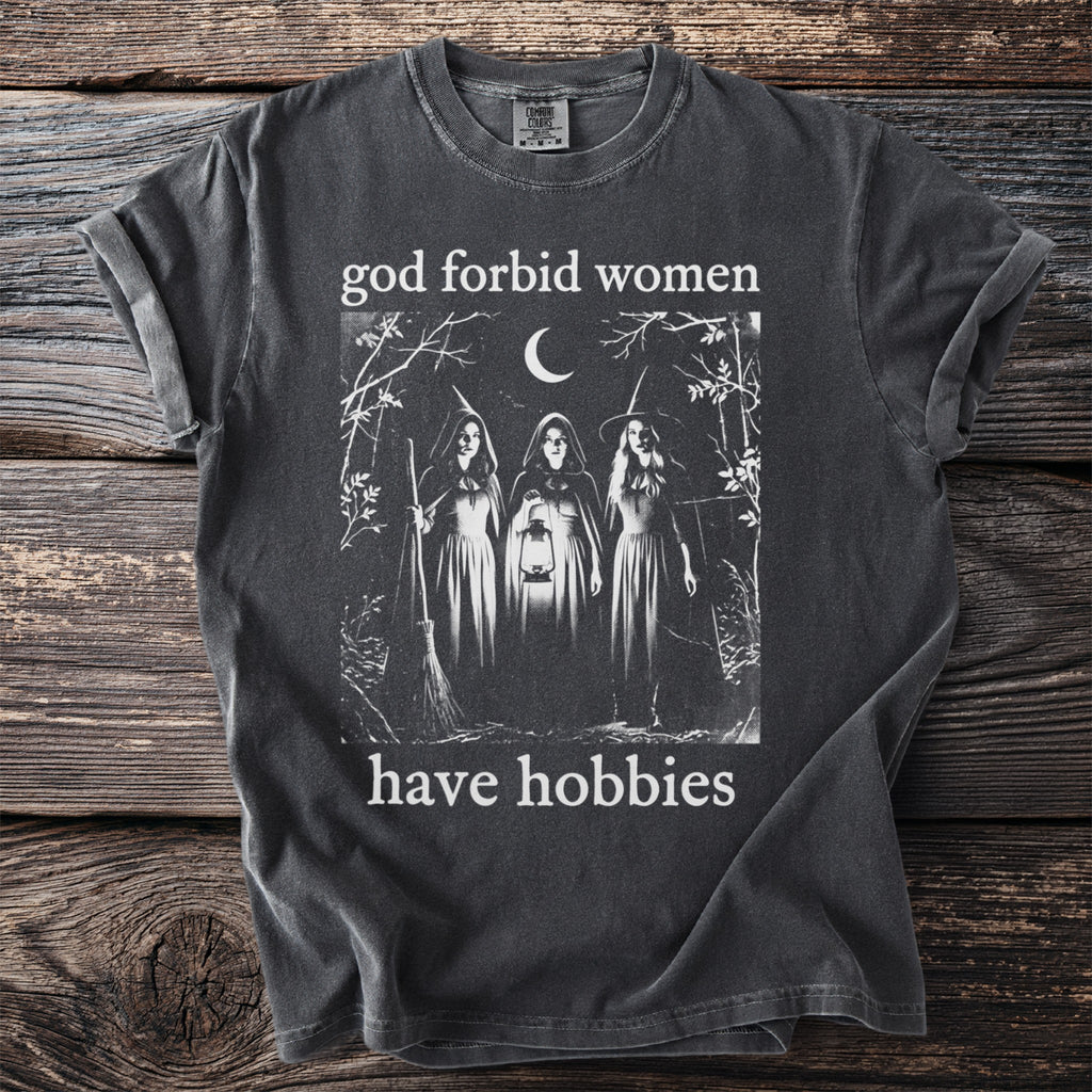 Dark grey t-shirt with "god forbid women have hobbies" and three witches graphic.