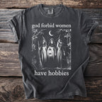 Dark grey t-shirt with "god forbid women have hobbies" and three witches graphic.