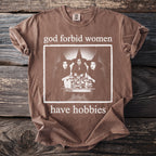 Brown t-shirt with "god forbid women have hobbies" text and witch graphic.
