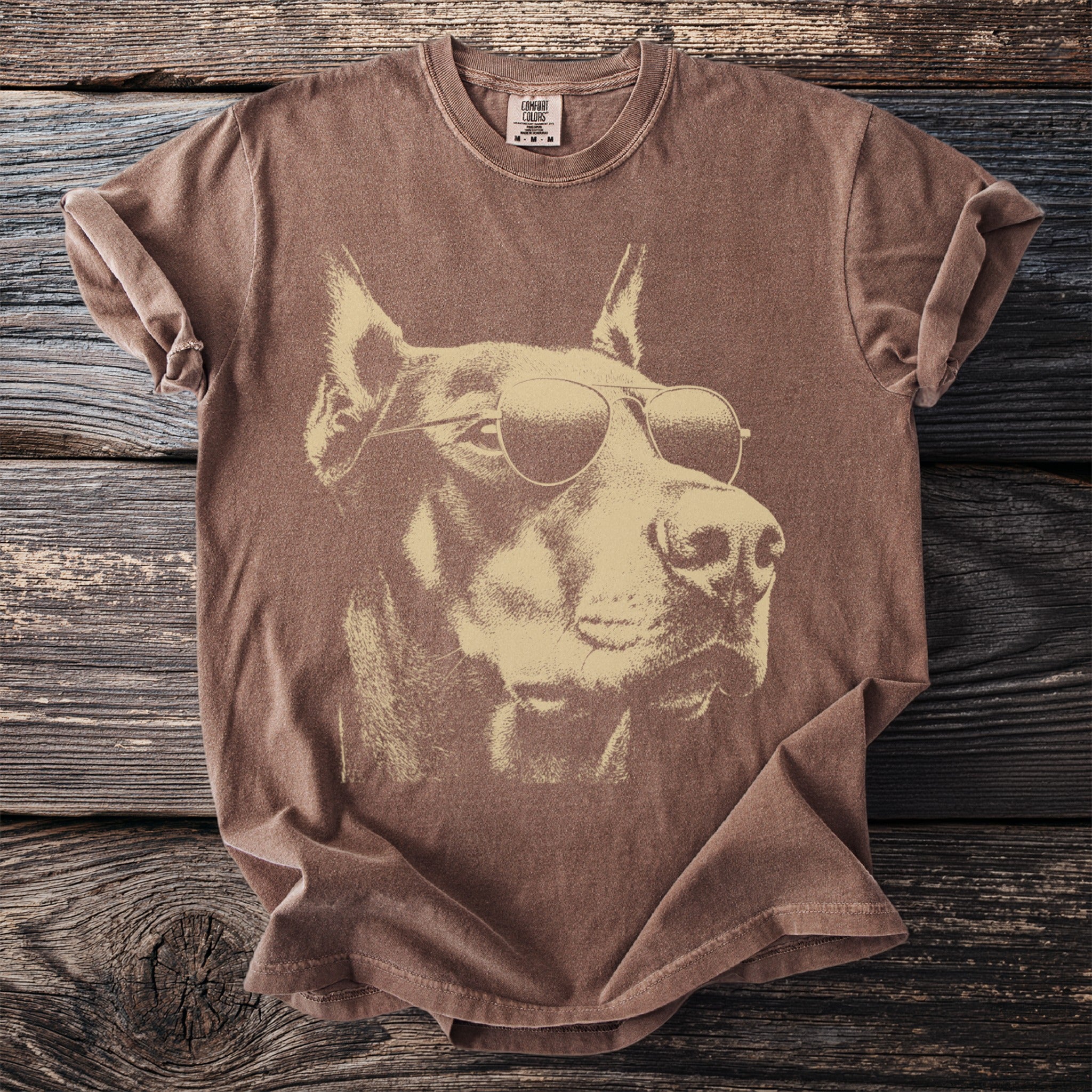 Brown t-shirt featuring a graphic of a Doberman wearing sunglasses.