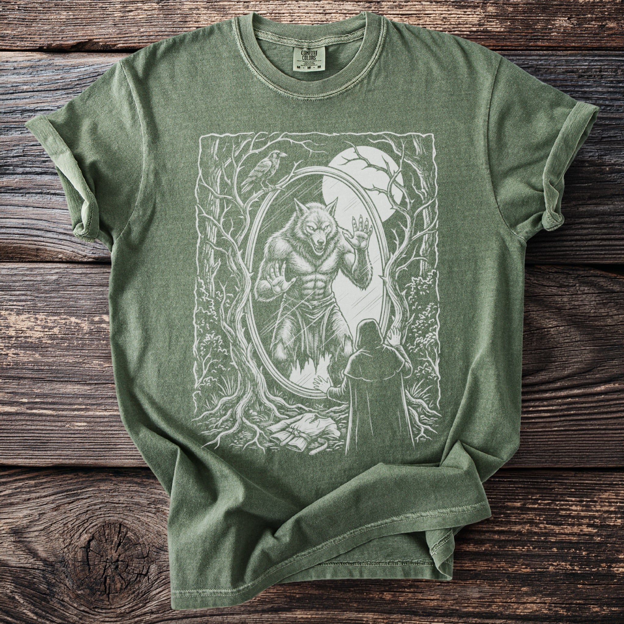 Green t-shirt with a white graphic of a werewolf in a mirror and a cloaked figure.