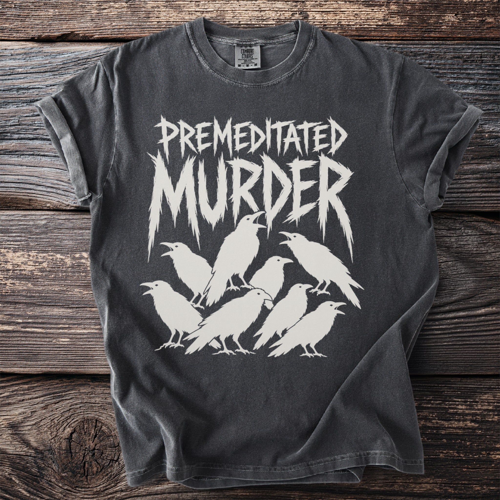 Dark t-shirt with white graphic of "PREMEDITATED MURDER" text and seven ravens.