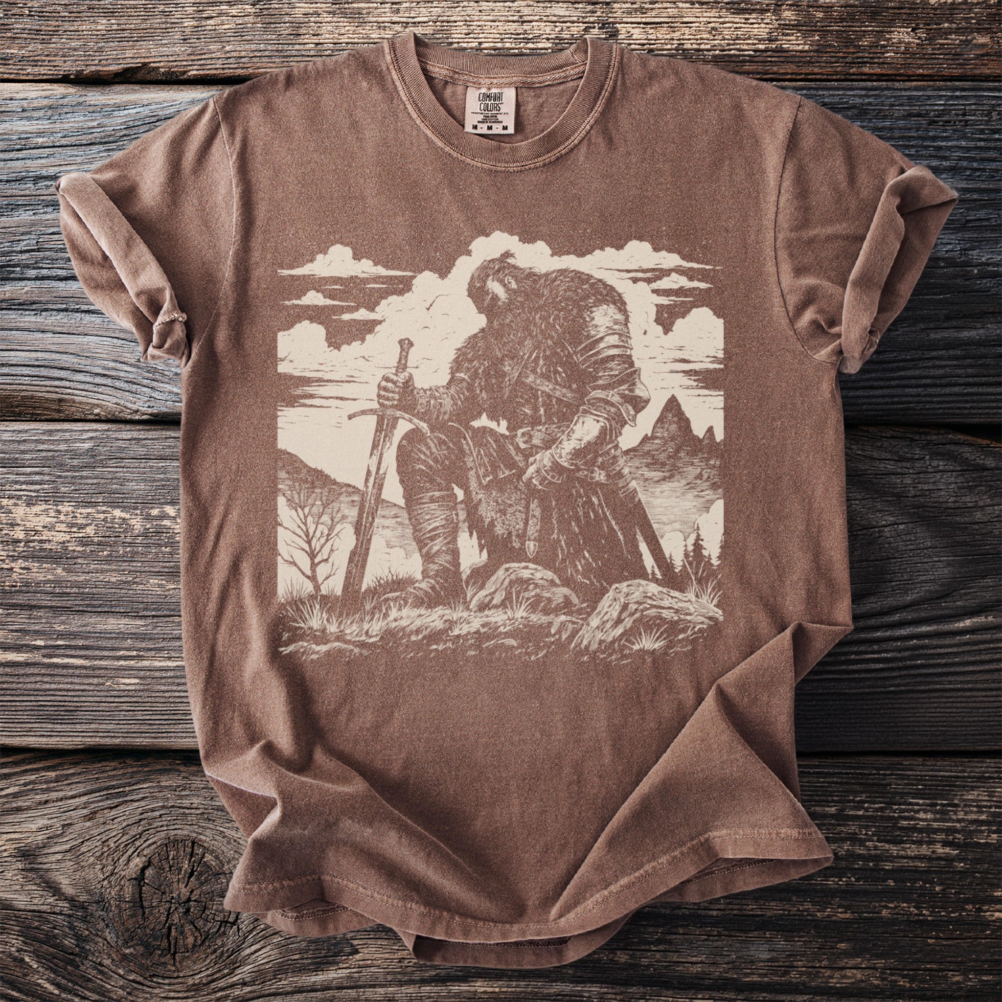 Brown t-shirt with illustration of a kneeling armored warrior holding a sword.