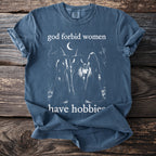 Blue t-shirt with "God forbid women have hobbies" text and three witches.