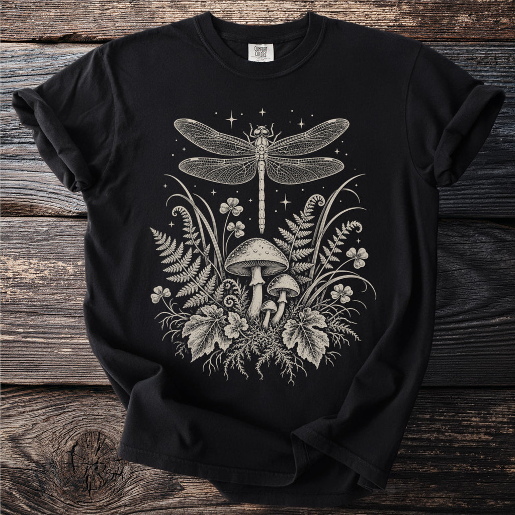 Black t-shirt with line art print of dragonfly, mushrooms, ferns, and stars.