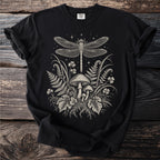 Black t-shirt with line art print of dragonfly, mushrooms, ferns, and stars.