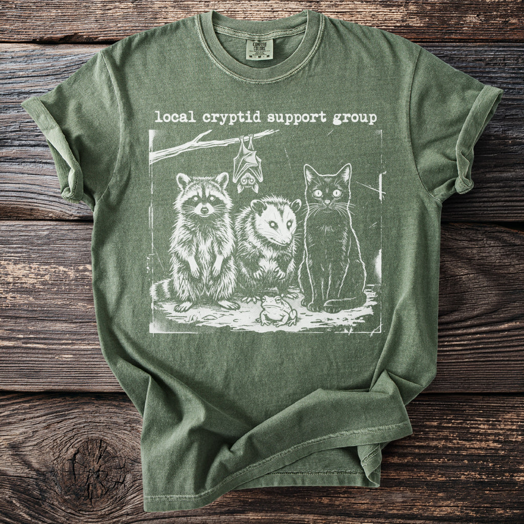 Green t-shirt with 'Local Cryptid Support Group' text and illustration of a raccoon, opossum, cat, bat, and frog.