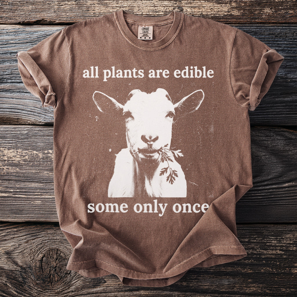 Brown shirt with a white graphic of a goat eating parsley and text.