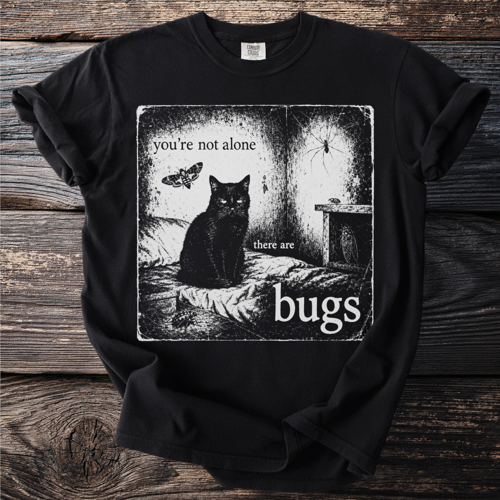 Black t-shirt with graphic featuring a black cat, moth, spider, and text "you're not alone there are bugs".