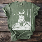 Green t-shirt with a white graphic of a cat wearing sunglasses, drinking from a cup.