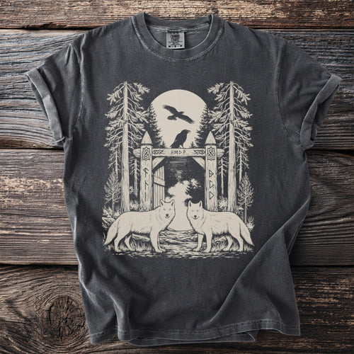 T-shirt graphic with two wolves, a wooden gate, trees, and birds under a moon.