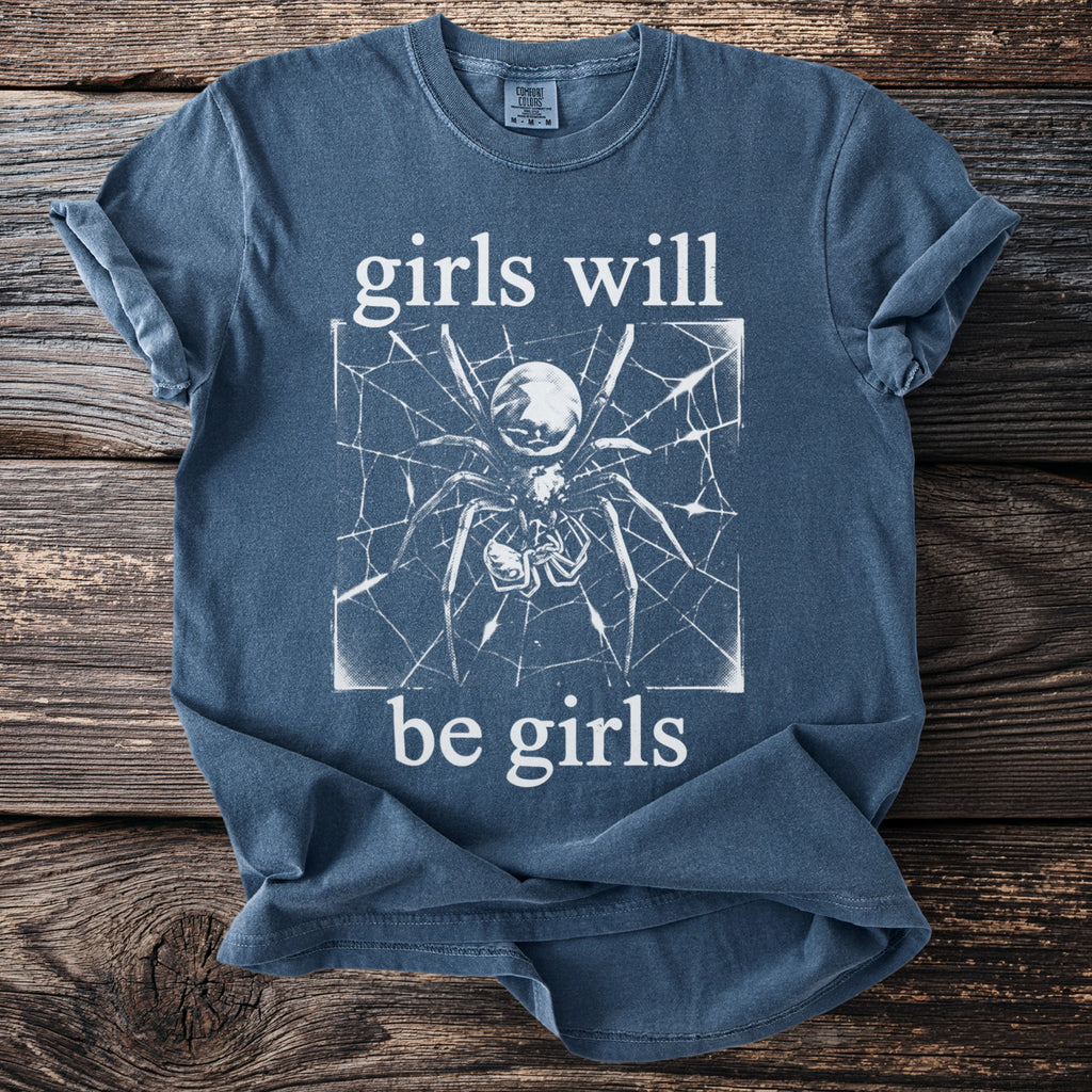 Blue t-shirt with a white spider graphic and text "girls will be girls".