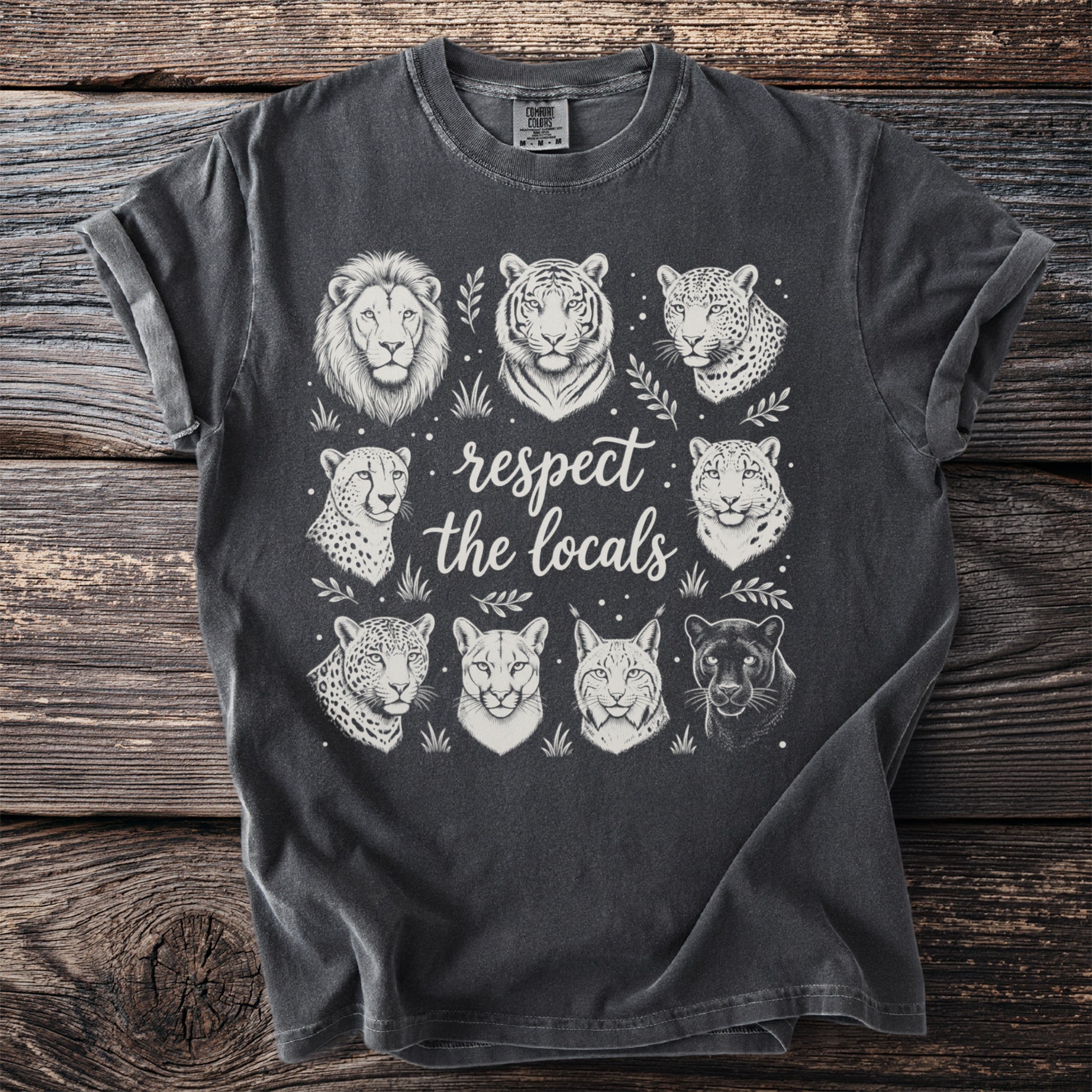 Dark t-shirt with a circular graphic of eight wild cat heads and the text "respect the locals".